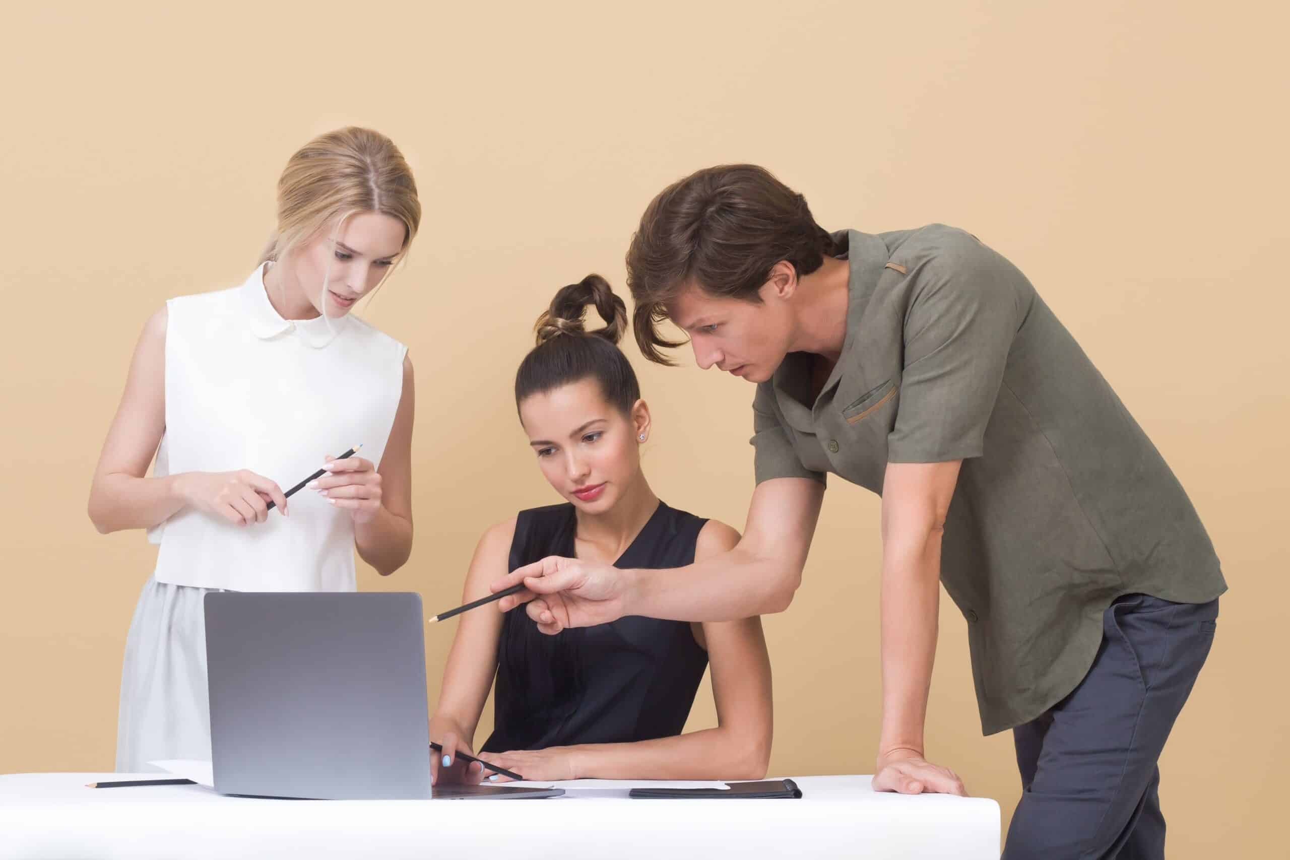 Two woman and one man looking at the laptop